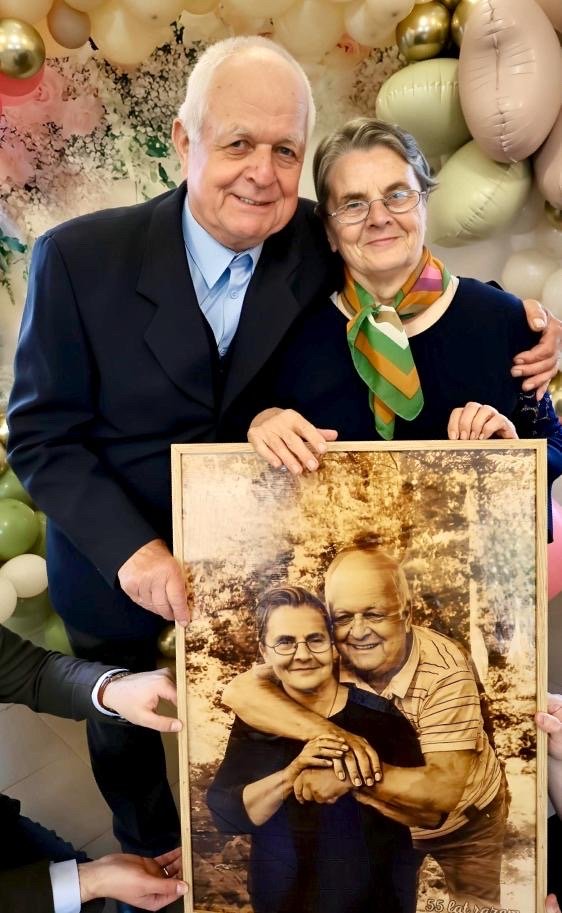 Małżeństwo trzymające portret na drewnie przygotowany na rocznicę ślubu