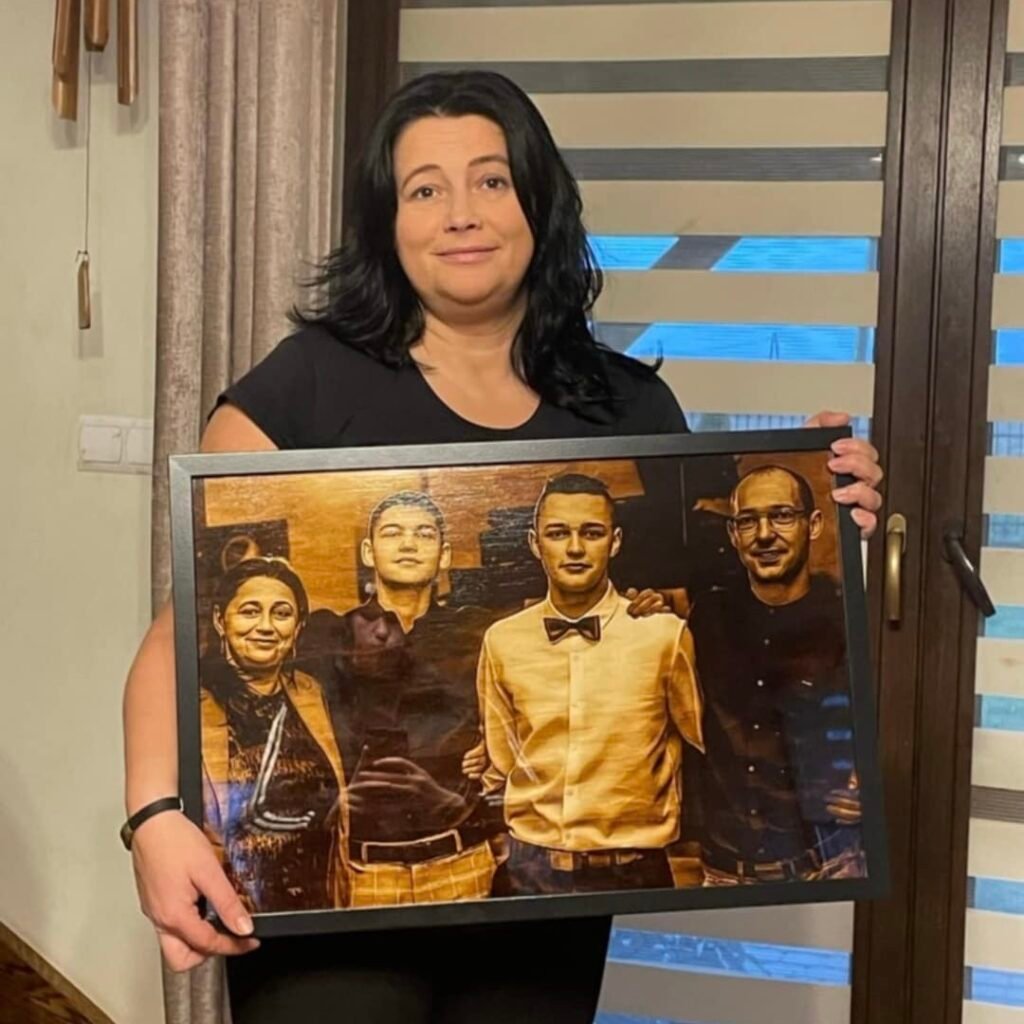 Kobieta trzymająca duży rodzinny portret na drewnie